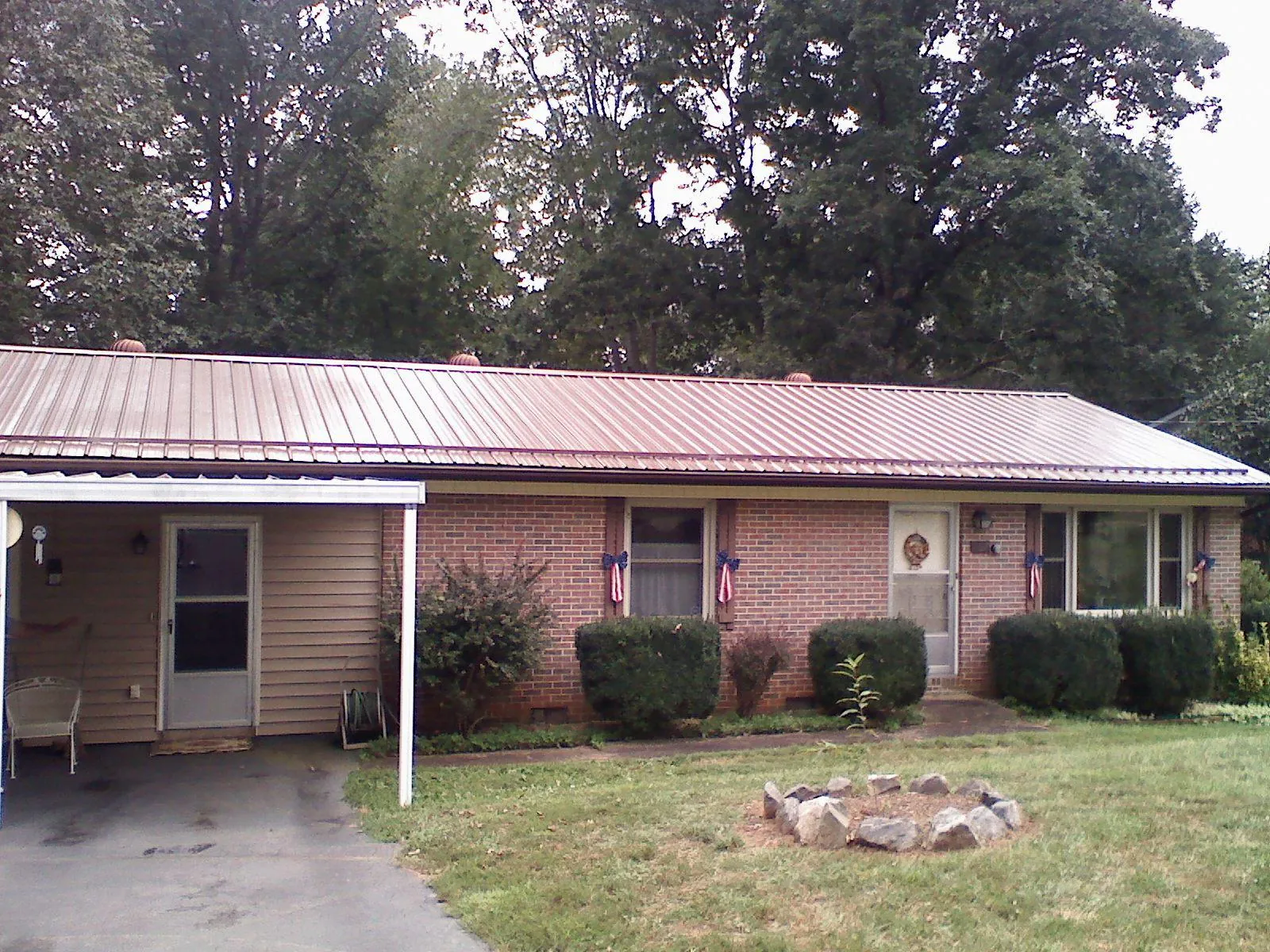 Bronze metal roof and carport on a brick ranch home — Roof Repair work by our crew in Bowie